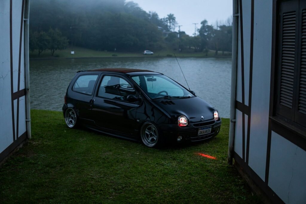 Black car parked by a lake at dusk