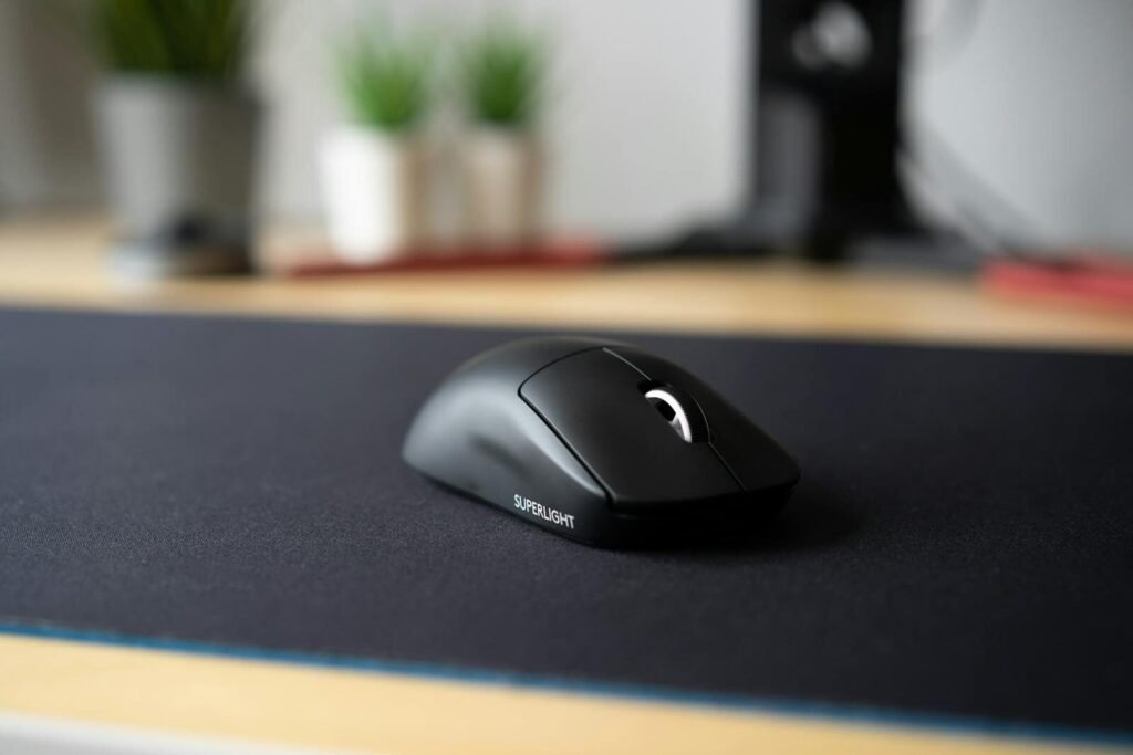 Sleek black wireless mouse on a modern desk with a blurred background, emphasizing minimalism.