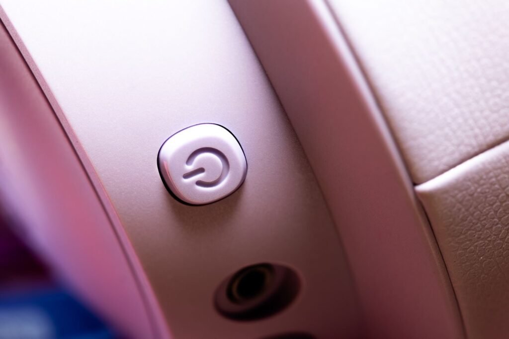 Detailed macro shot of a pink headphone power button, focus on design.